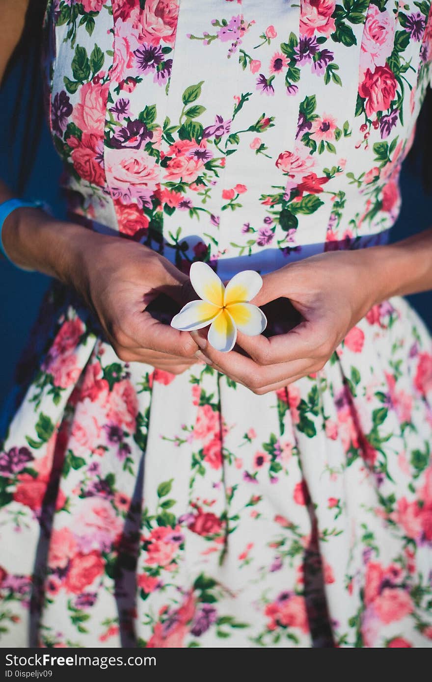 Woman in White and Green Floral Dress Holding Flower