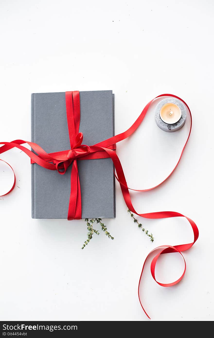 Gray Notebook Beside Tealight Candle