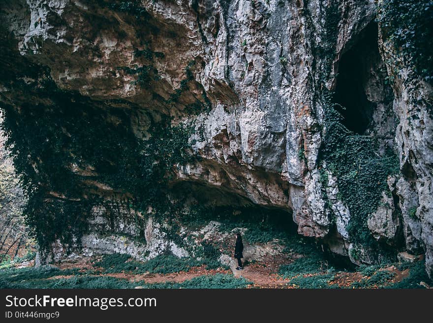 Person Under Black and Gray Cliff