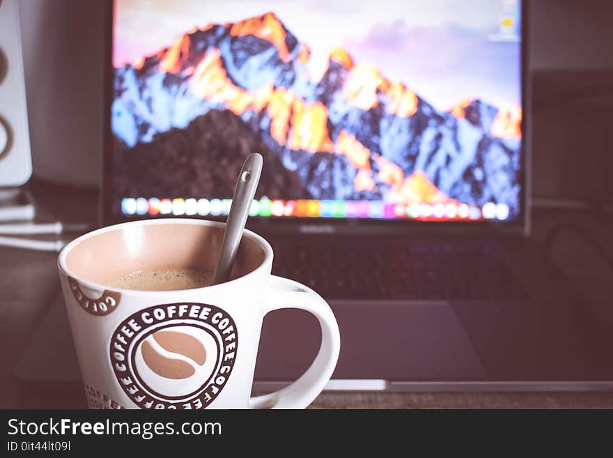 Photo of Cup of Coffee in Front of the Laptop