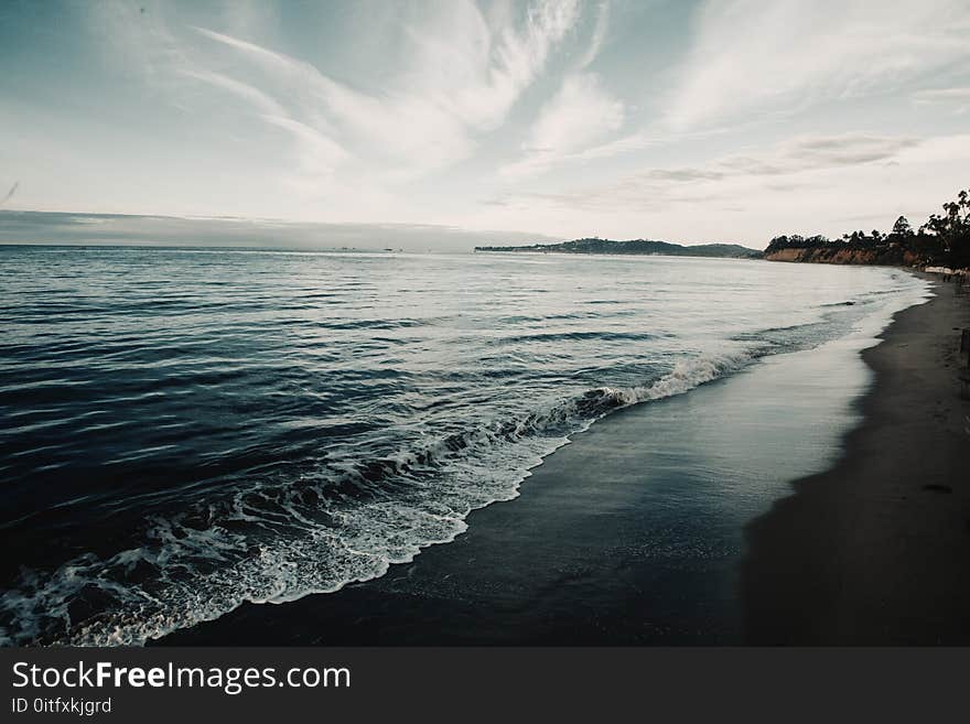 Shoreline Under Blue Sky