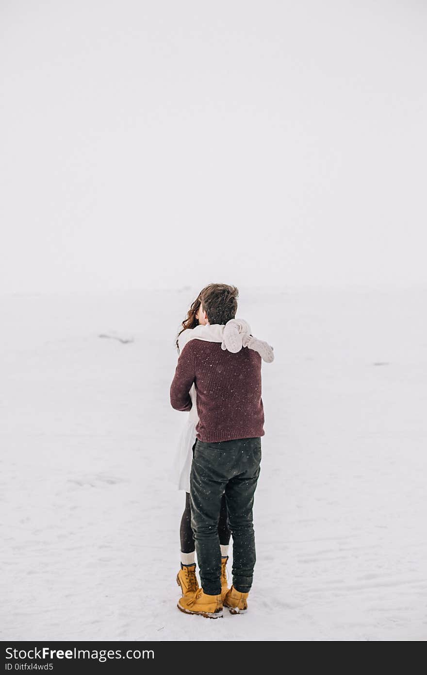 Man and Woman Kissing on Snow Field