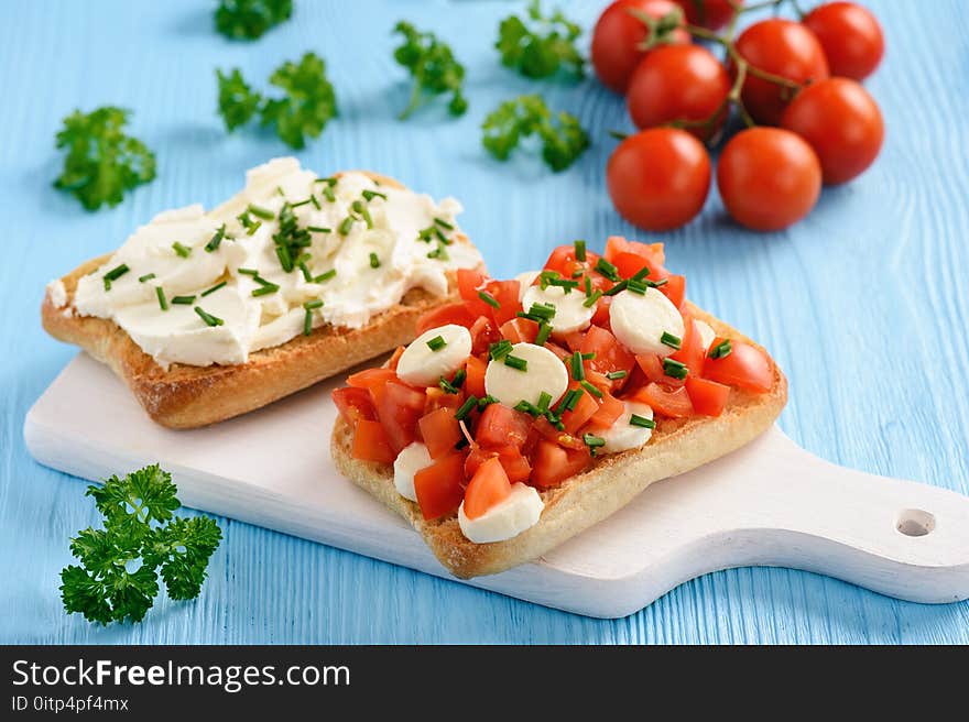 Variety of sandwiches with tomatoes, mozzarella, avocado, eggs and cream cheese.