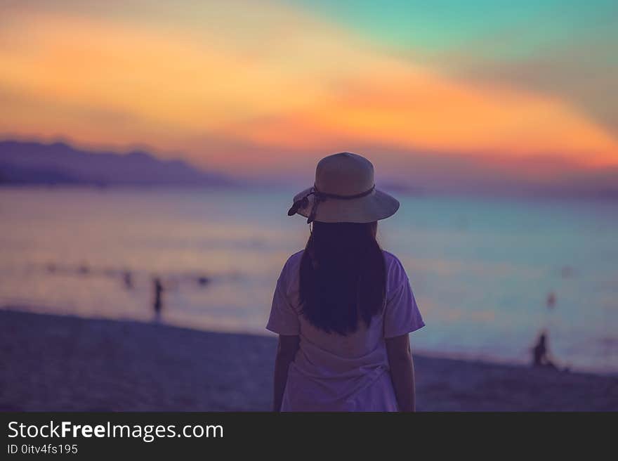 Woman in White Dress Standing Near Beach during Sunset