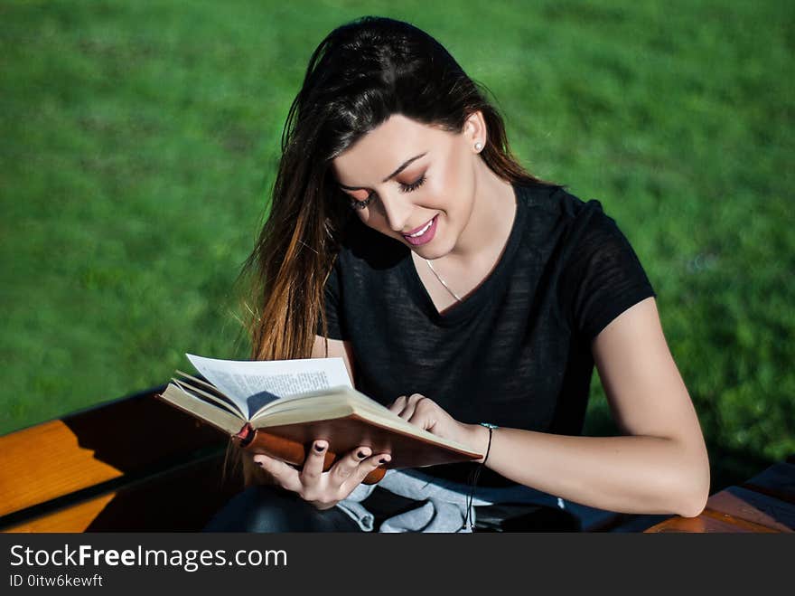 Happy Beautiful Girl Reading A Book On Sunny Spring Day On A Bench In Nature