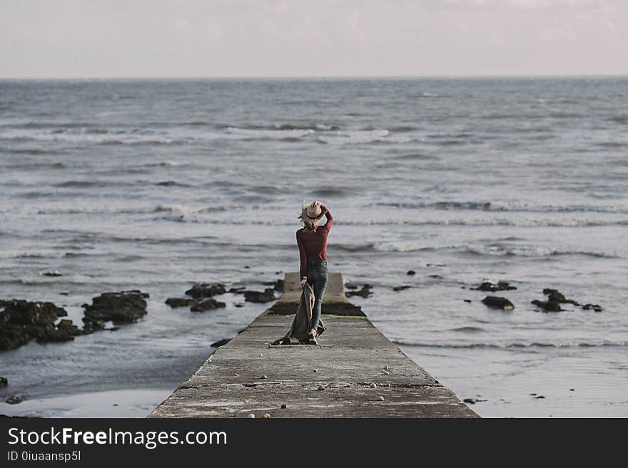 Person Standing on Dock Holding Textile