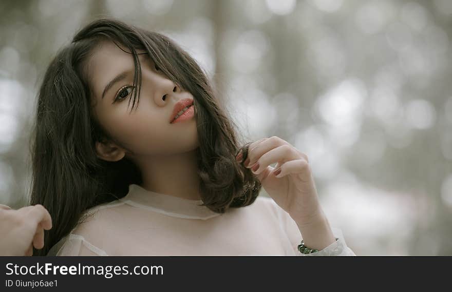 Long Black Haired Woman in Grey Top Taking Selfie