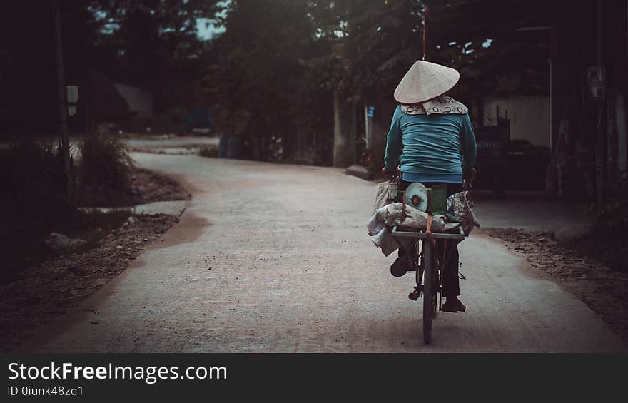 Person Riding a Bicycle Cycling on Road