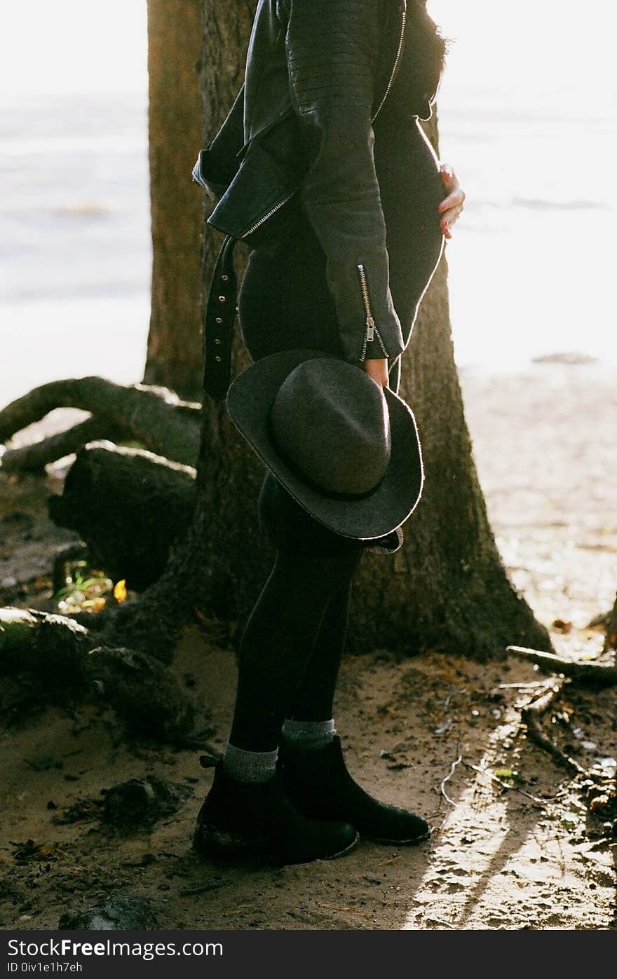 Photo of Pregnant Woman Standing Behind the Tree