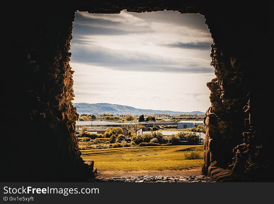 Rock Formation With Grassfield Background