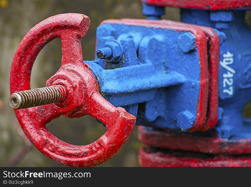 Steam pipe valve in red and blue colors with blurred background