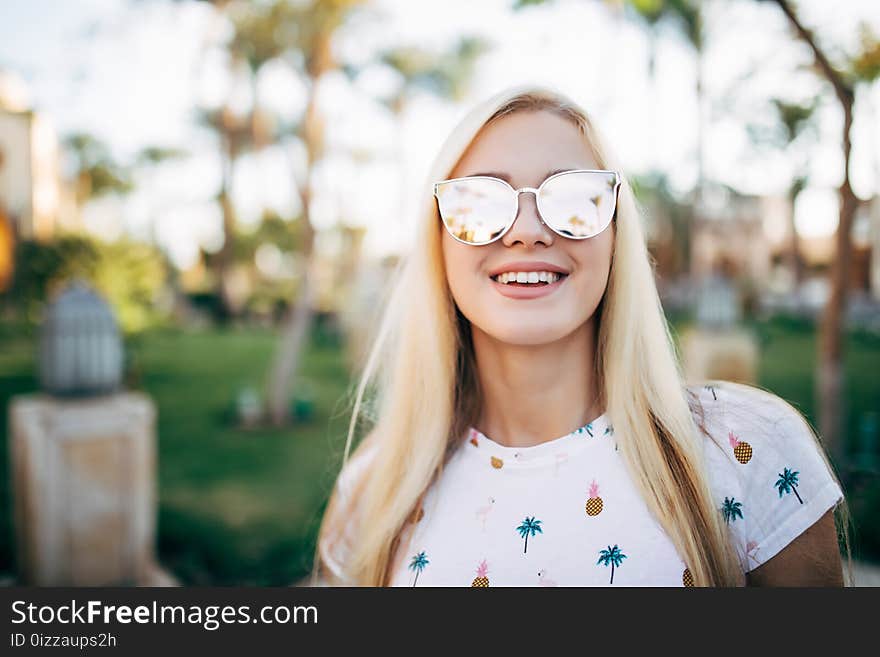 Close up portrait woman wearing sunglasses posing with palm tree