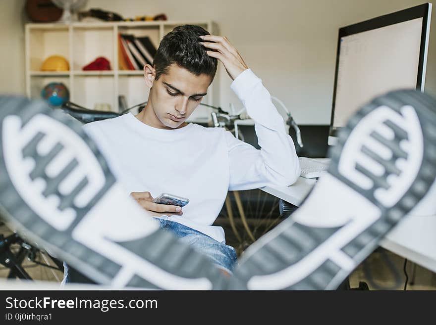 Young man smiling with the mobile phone at home