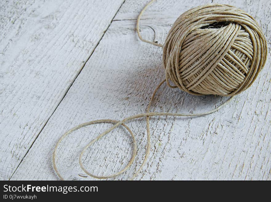 Ball of hemp twine on white wooden background with space for text