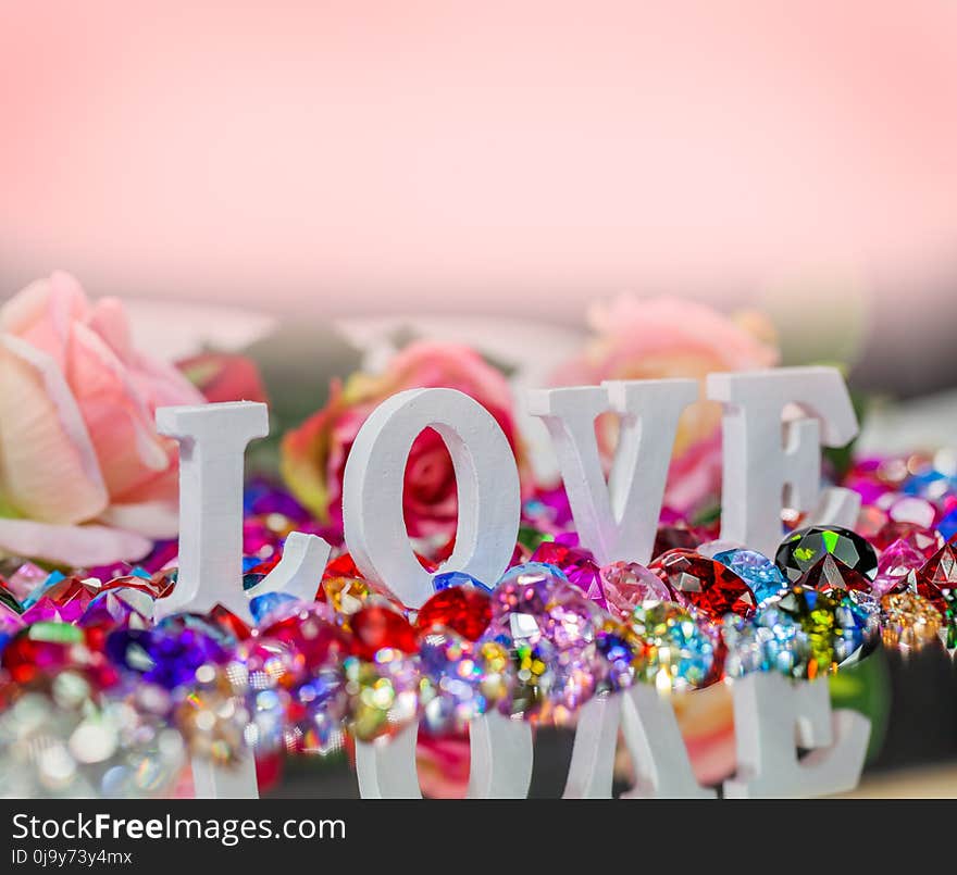 The word love is located on the area of colorful diamonds and roses, the word love is love for Valentine`s Day. The word love is located on the area of colorful diamonds and roses, the word love is love for Valentine`s Day.