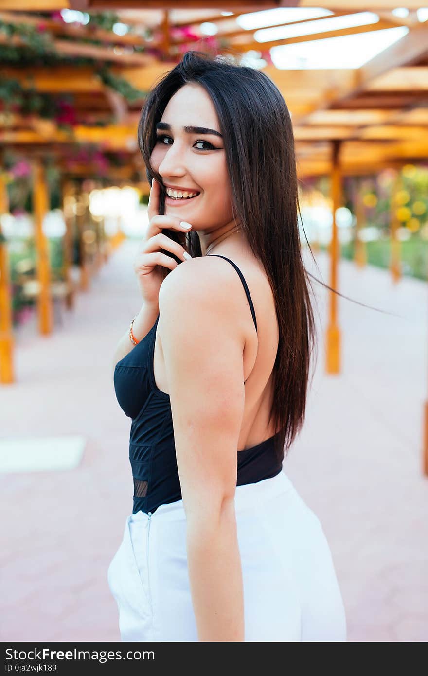 Fashion stylish trendy sensual portrait of pretty young woman posing outdoor in summer in the beach cafe having fun alone