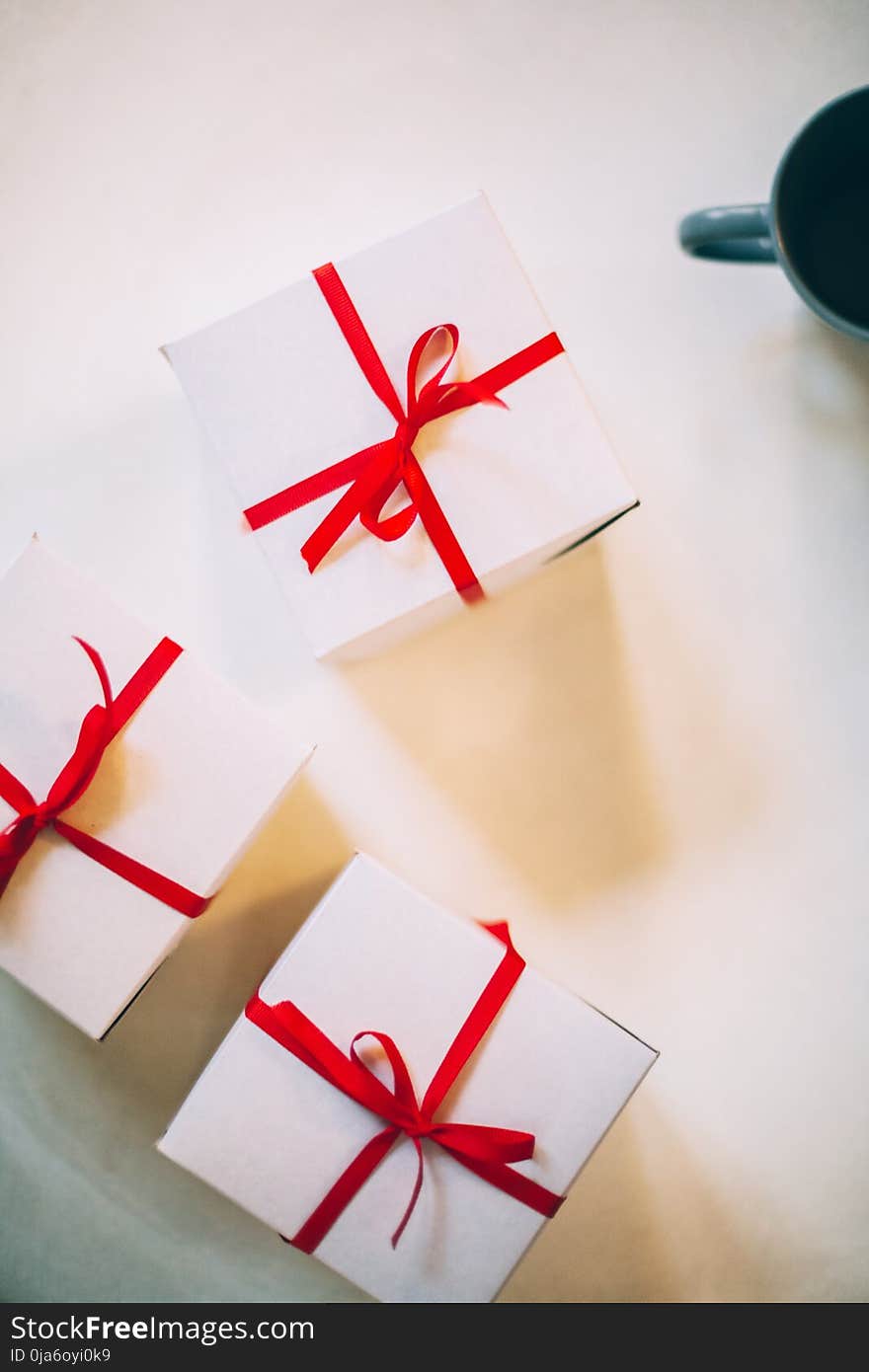 Photography of Three Boxes With Red Ribbons