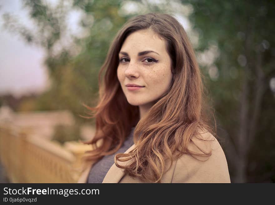 Closeup Photo of Woman With Brown Coat and Gray Top