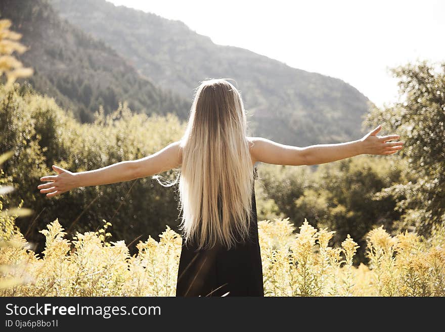 Standing Man in Black Dress Facing Mountain