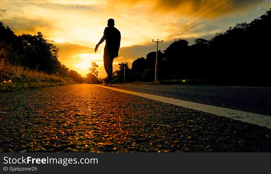 Silhouette Photo Of Man Riding Skateboard