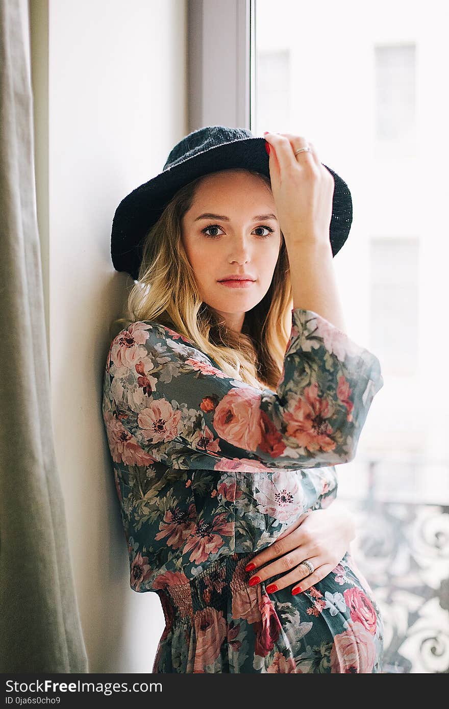 Woman in Multicolored Floral Long-sleeved Dress and Black Hat