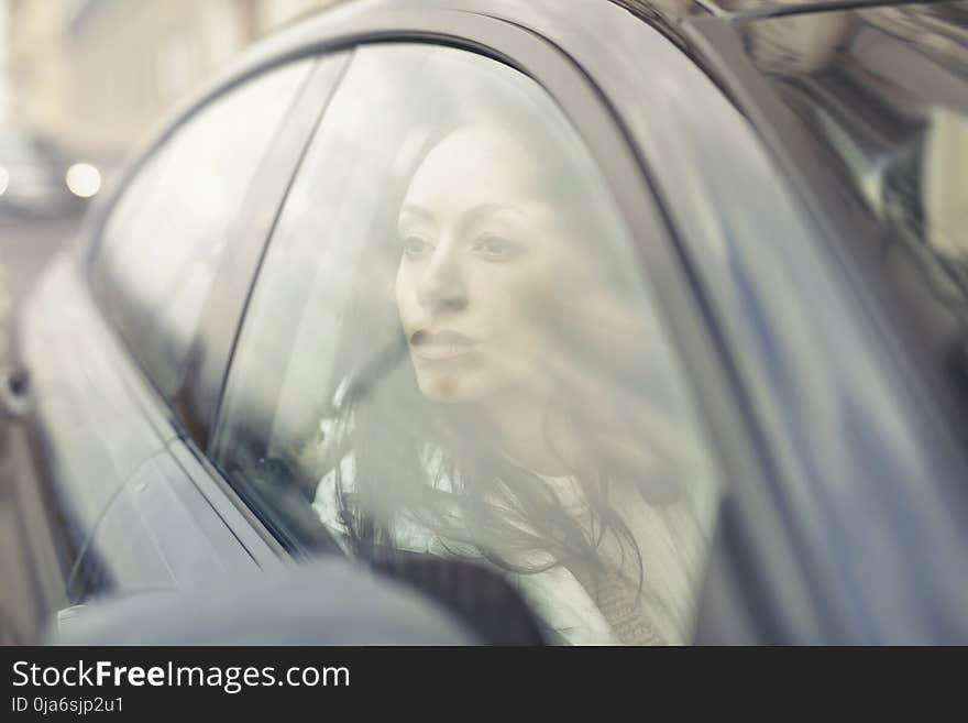 Woman Inside the Black Sedan at Daytime