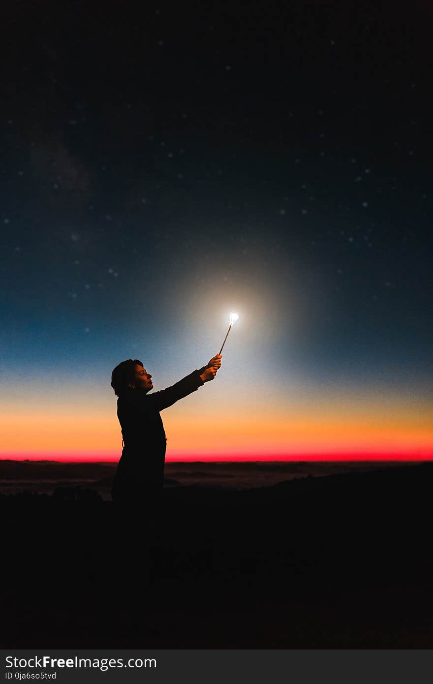 Person Holding Roman Candle at Night