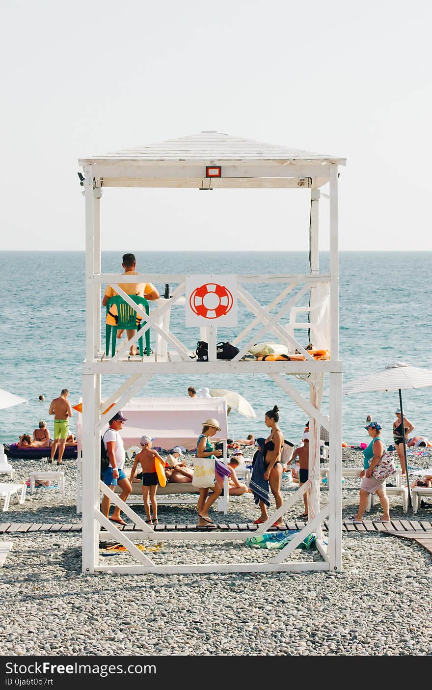 People Near Beach With Lifeguard Gazebo