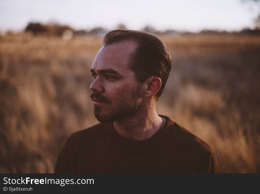 Man Wearing a Brown Crew-neck Shirt on a Field