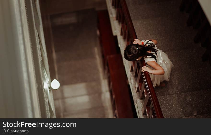 Girl in White Dress Standing in Front of Railings