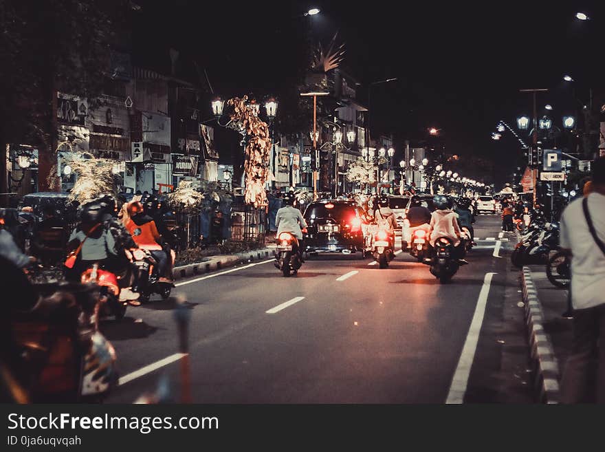 People Riding Motorcycles On Road During Night Time