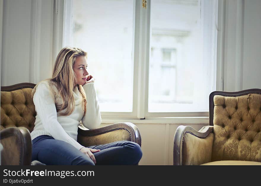 Photography of Woman Sitting on Chair Near Window