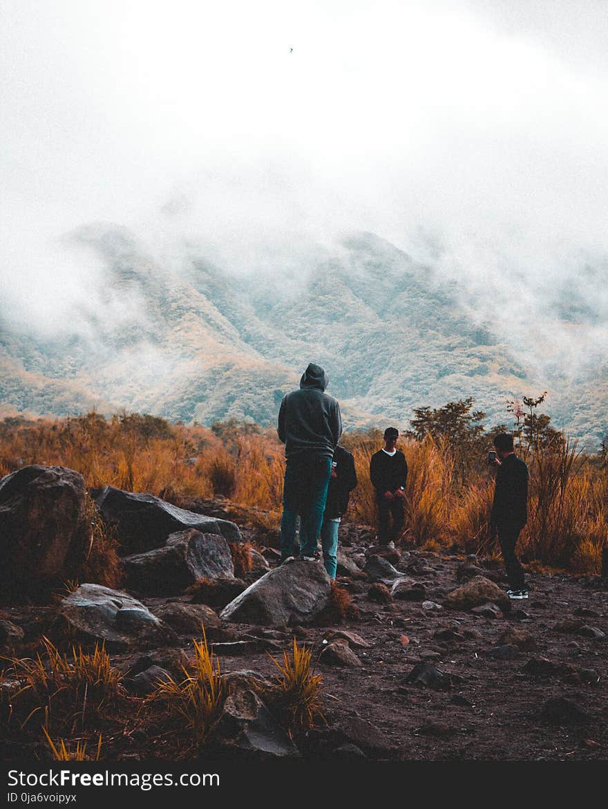 Group of People Near Foggy Mountain