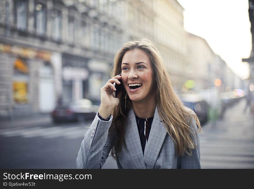 Blonde Hair Woman Wearing Gray Suit Jacket Holding Smartphone