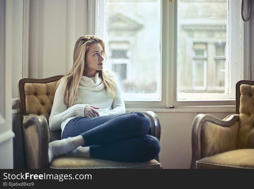 Photography of Woman Sitting on Chair Near Window