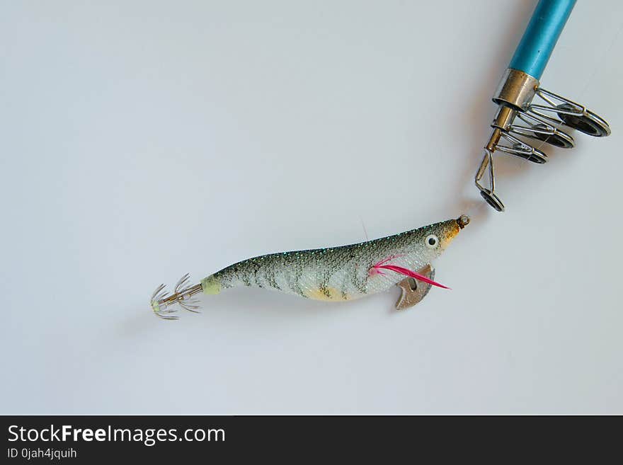 colorful plastic fishing bait on fishing pole on white background, space for text