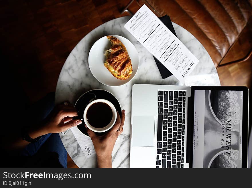 Macbook Pro and a Cup of Coffee on Table