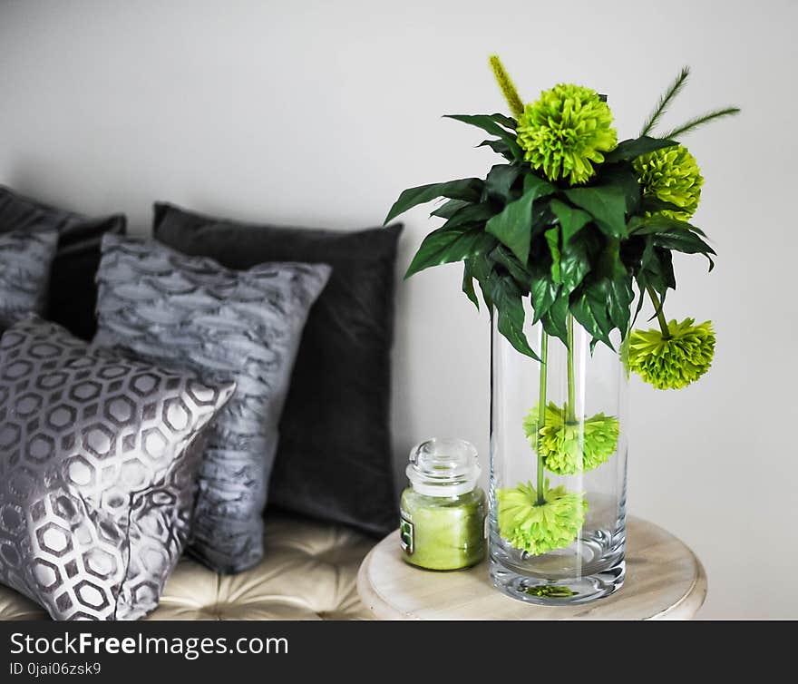 Clear Glass Vase With Green Flowers on Brown Wooden End Table