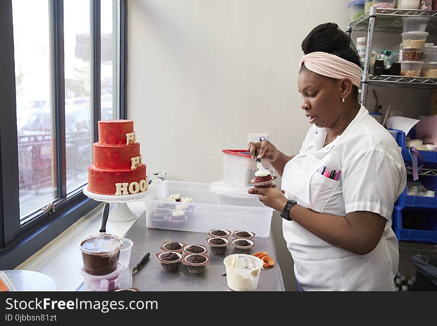 Young black woman frosting cakes at a bakery