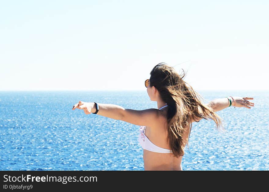 Woman Wearing White Bikini Top Standing Near Body of Water