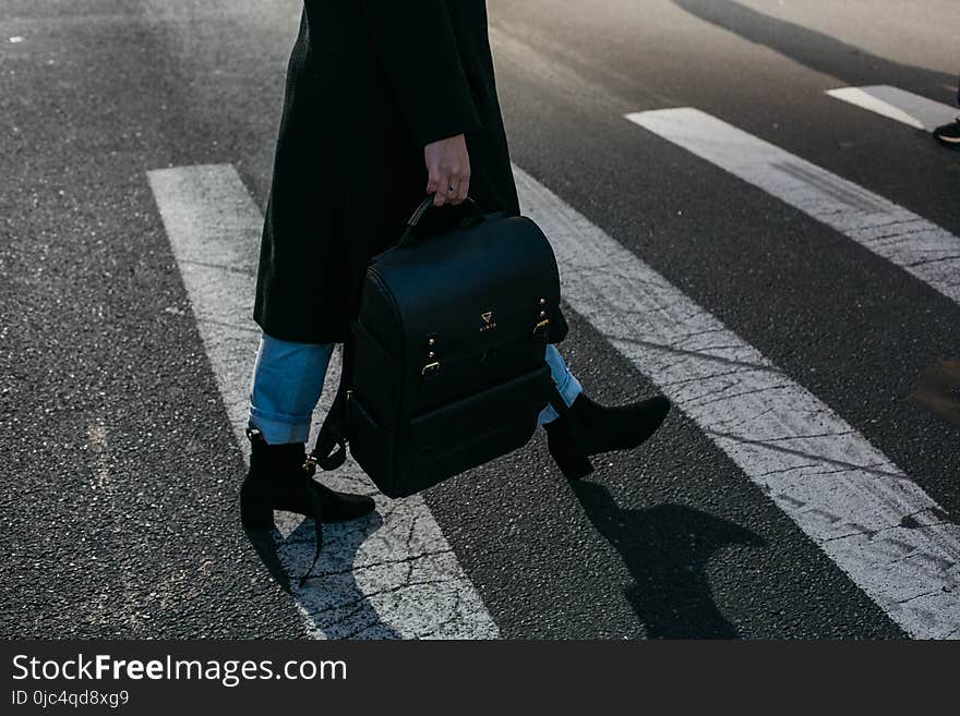 Person Carrying Bag Walking on Pedestrian Lane