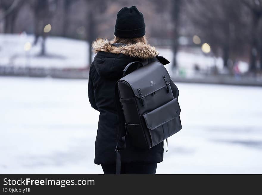 Woman Wearing Parka and Carrying Backpack during Winter