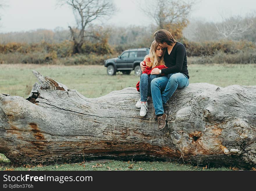 Mother and Daughter Sitting on Tree Log