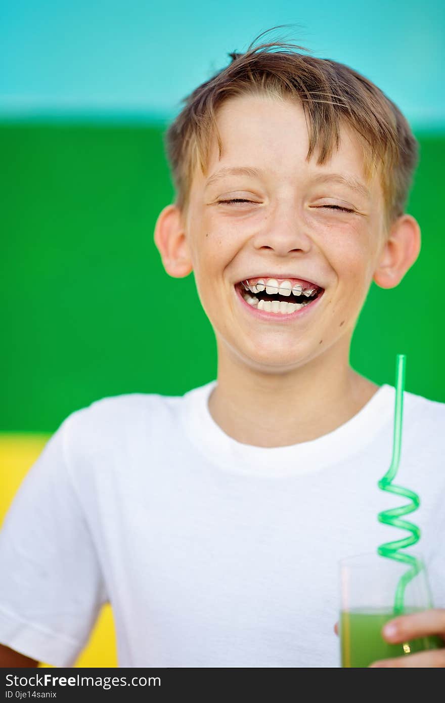 Cute , happy , smiling boy is drinking juice. Cute , happy , smiling boy is drinking juice