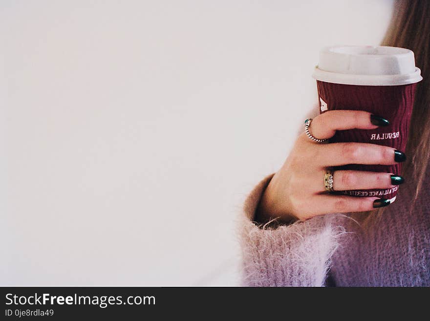 Person With Black Manicured Nails Holding Brown Cup With White Lid