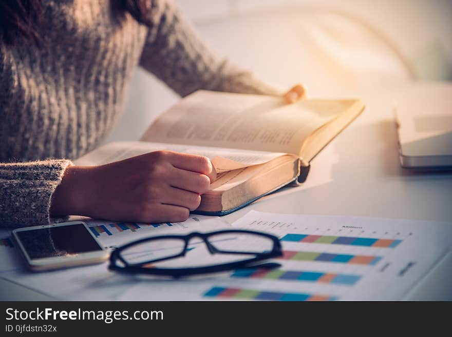 Focus hand open book for reading on desk work with gold lighting at the morning