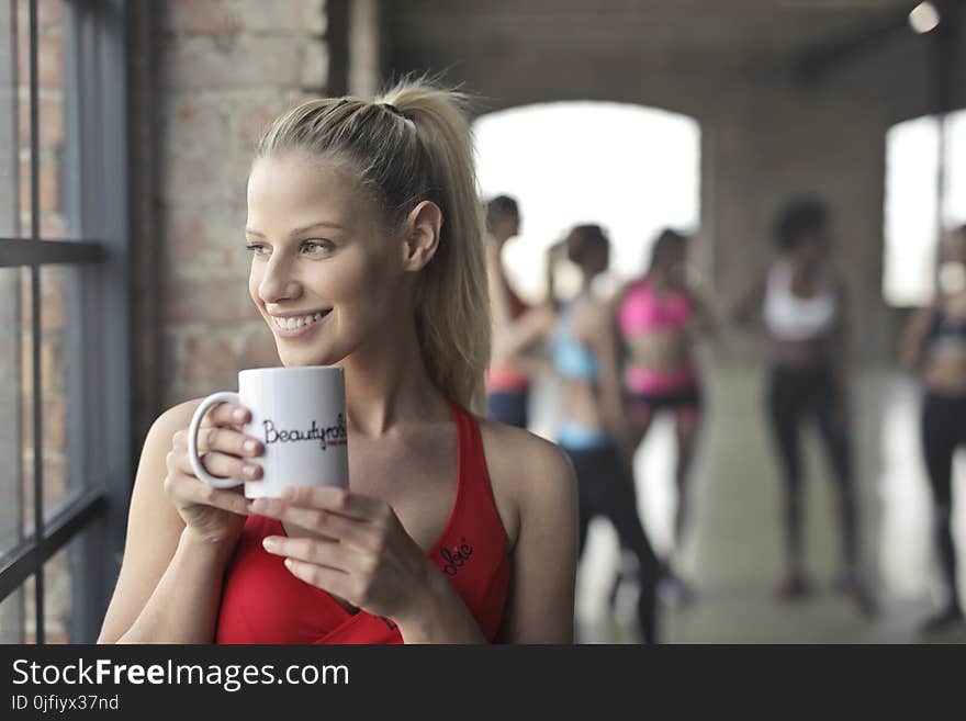 Woman Wearing Red Tank Top Holding White Ceramic Mug