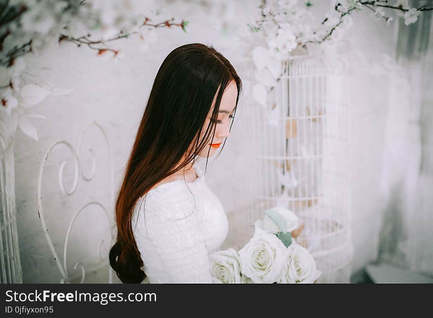 Woman Wearing Wedding Dress Holding Bouquet of Flower