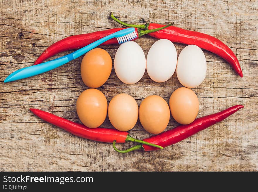 Eggs and red pepper in the form of a mouth with teeth. White eggs are bleached teeth. Yellow eggs - before bleaching. Teeth whitening before and after.