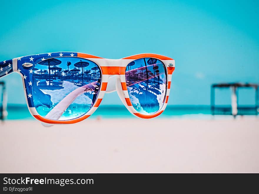 Focus Photography of American Flag-accent Wayfarer-styled Sunglasses With Sea Background